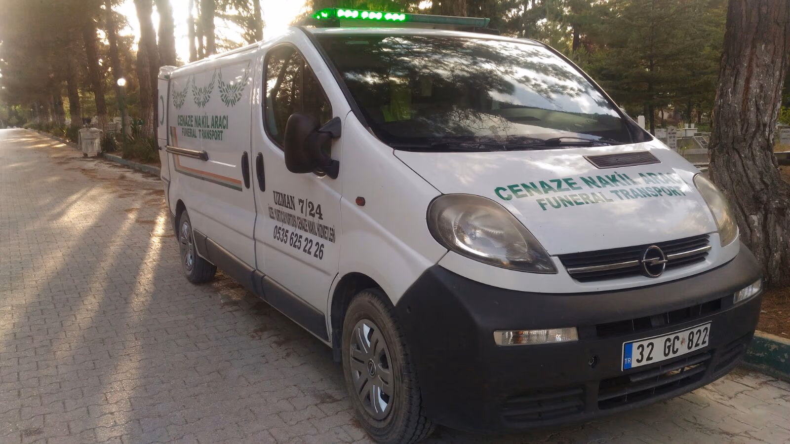 Fırat Cenaze Hizmetleri’ne ait, yan tarafında telefon numarası yazılı cenaze nakil aracı